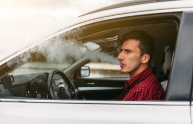 man smoking in a vehicle